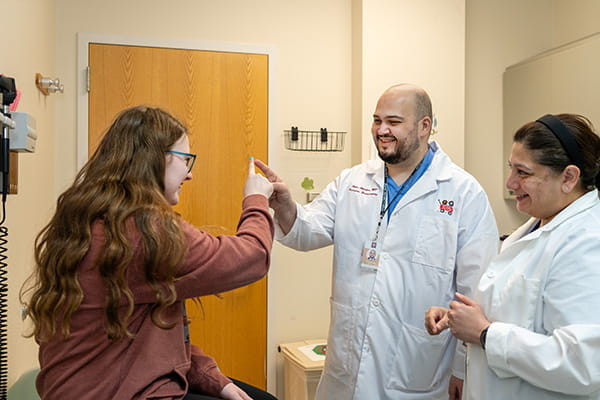 Two doctors meet with a patient in a clinic