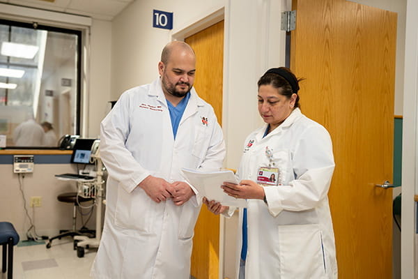 Two doctors look over notes in a hospital