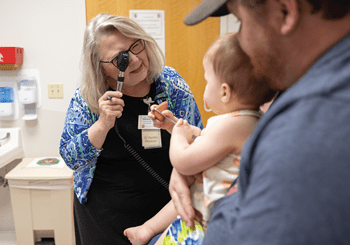a neurosurgeon visits with a child in the hospital