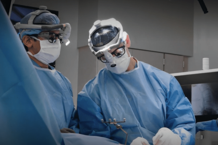 two spine surgeons operate on a patinet