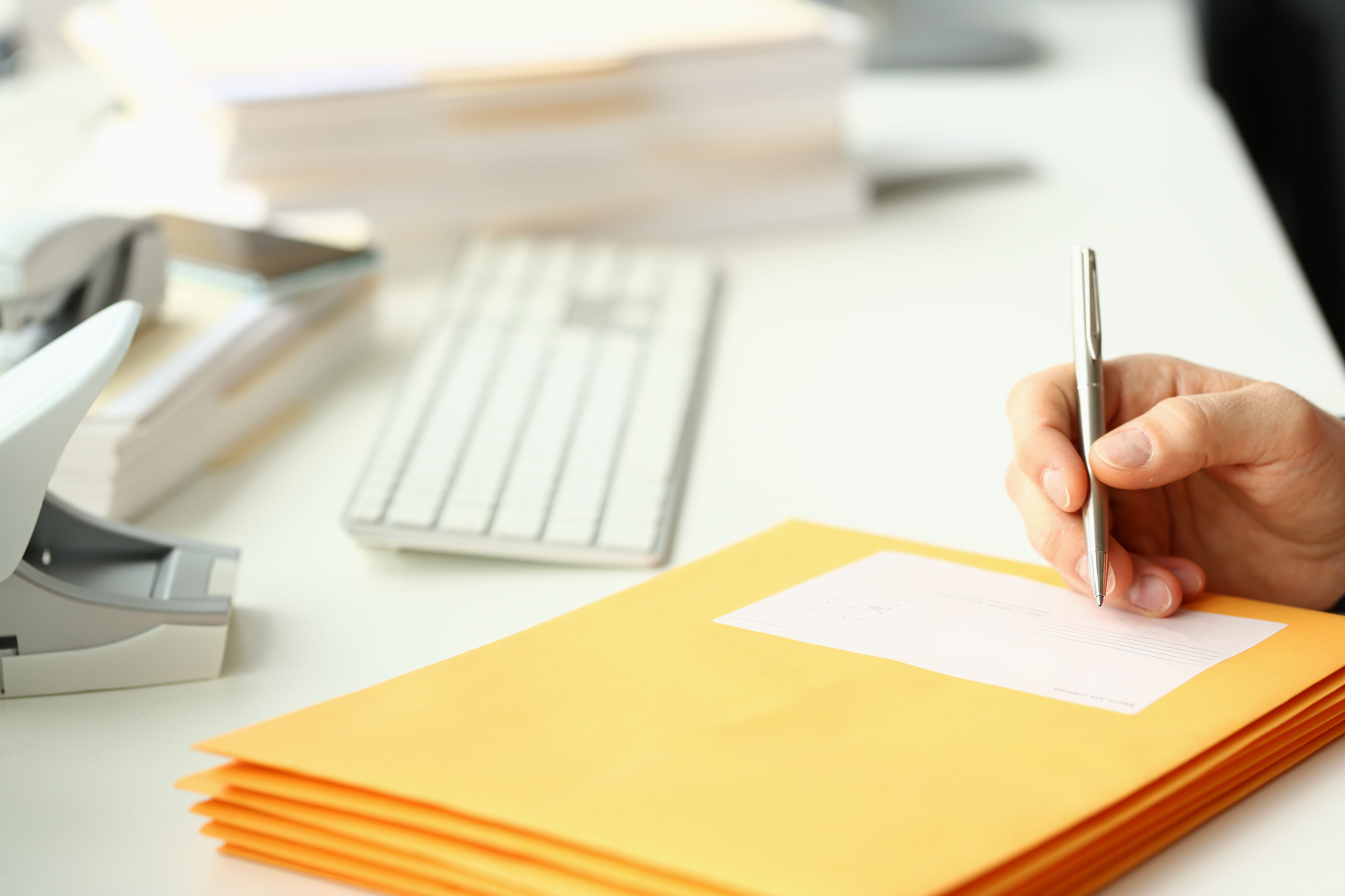 Person fills in addresses on a yellow envelope