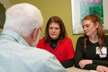two nurses meet with a patient