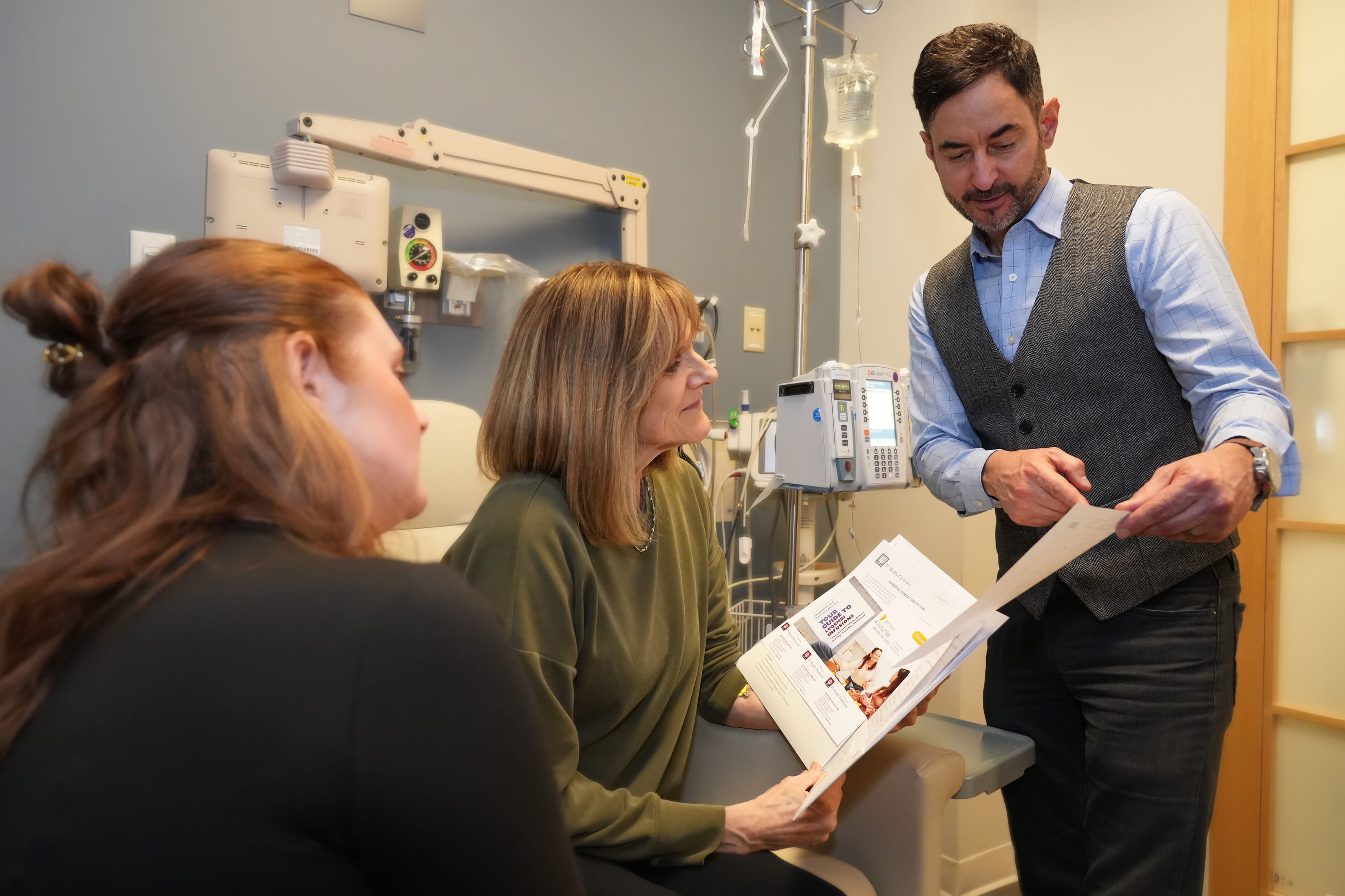 a physician shows a folder with documents to a patient