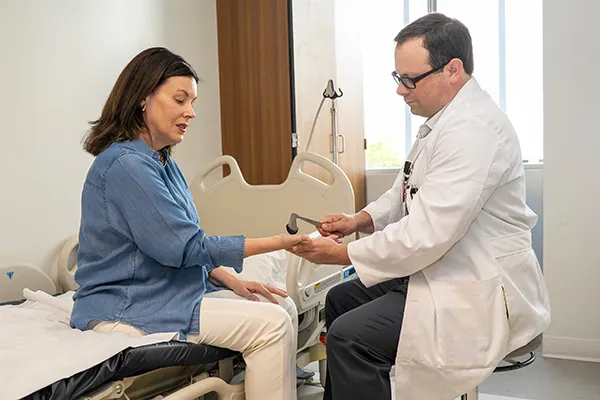 Dr. Adam Comer examines a myotonic dystrophy patient in the clinic.