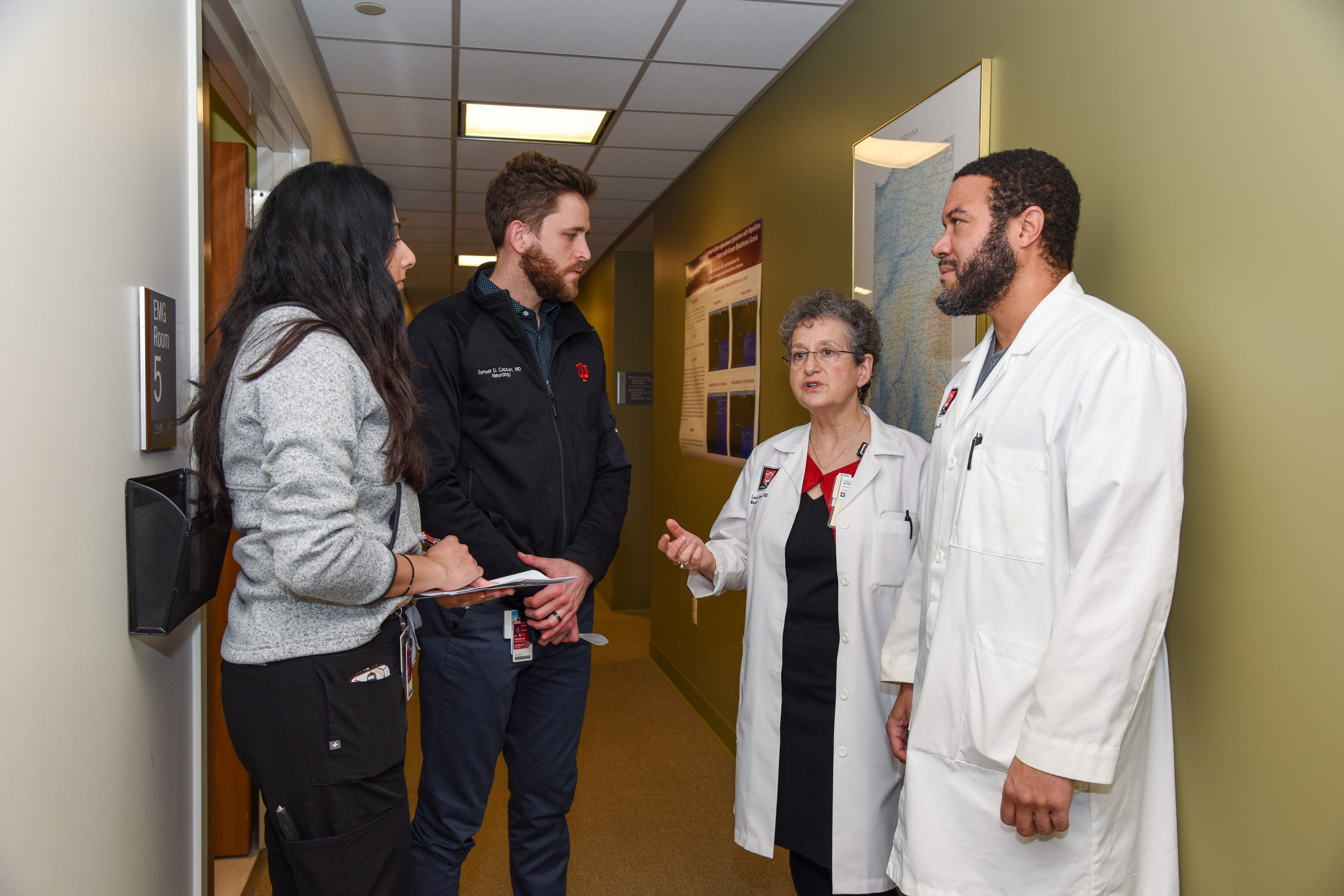 Neurology faculty and residents chat in a hallway