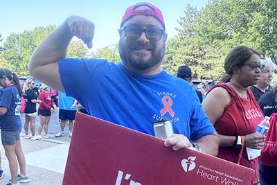 A man flexes his arm after a stroke awareness race