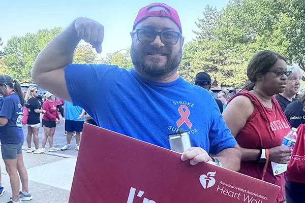A man flexes his arm after a stroke awareness race 