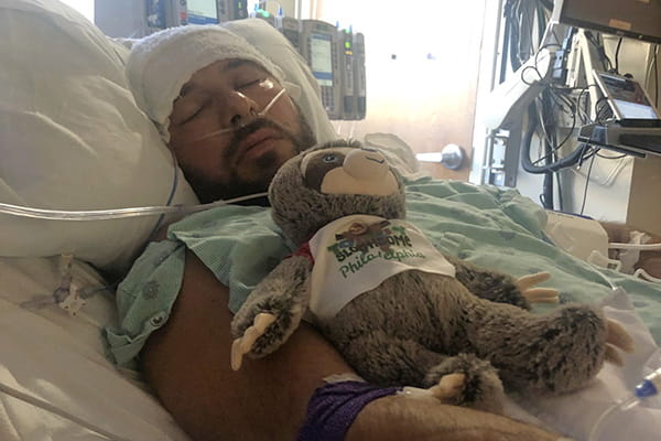 A man sleeps in a hospital bed post-surgery