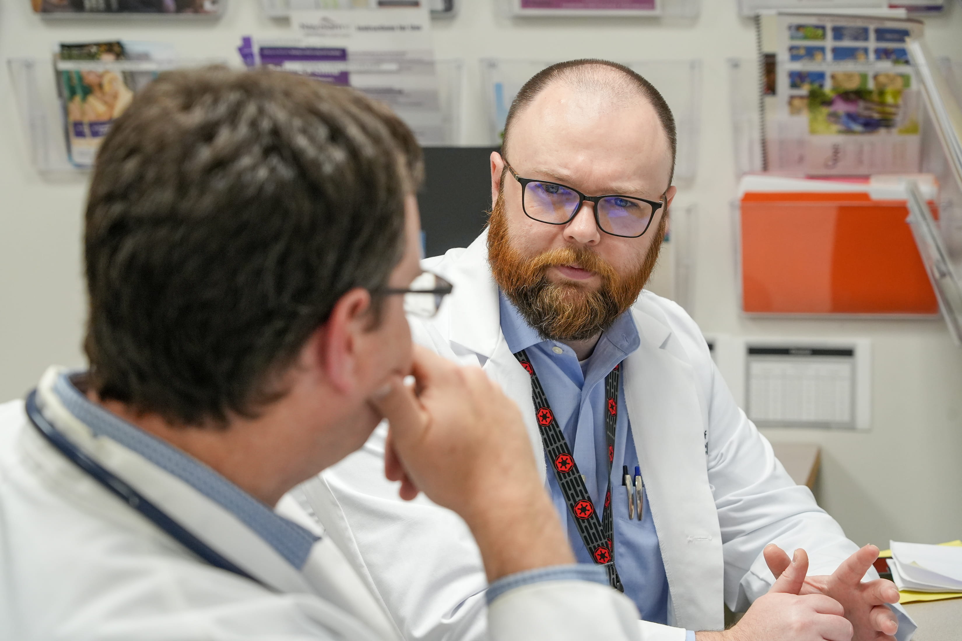 a pediatric neurologist and resident talk in the clinic
