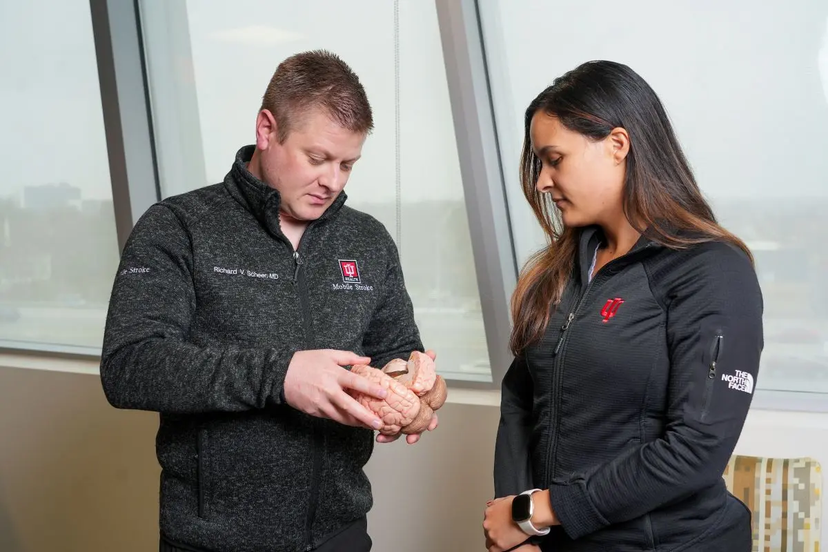 a faculty member and resident study a model brain