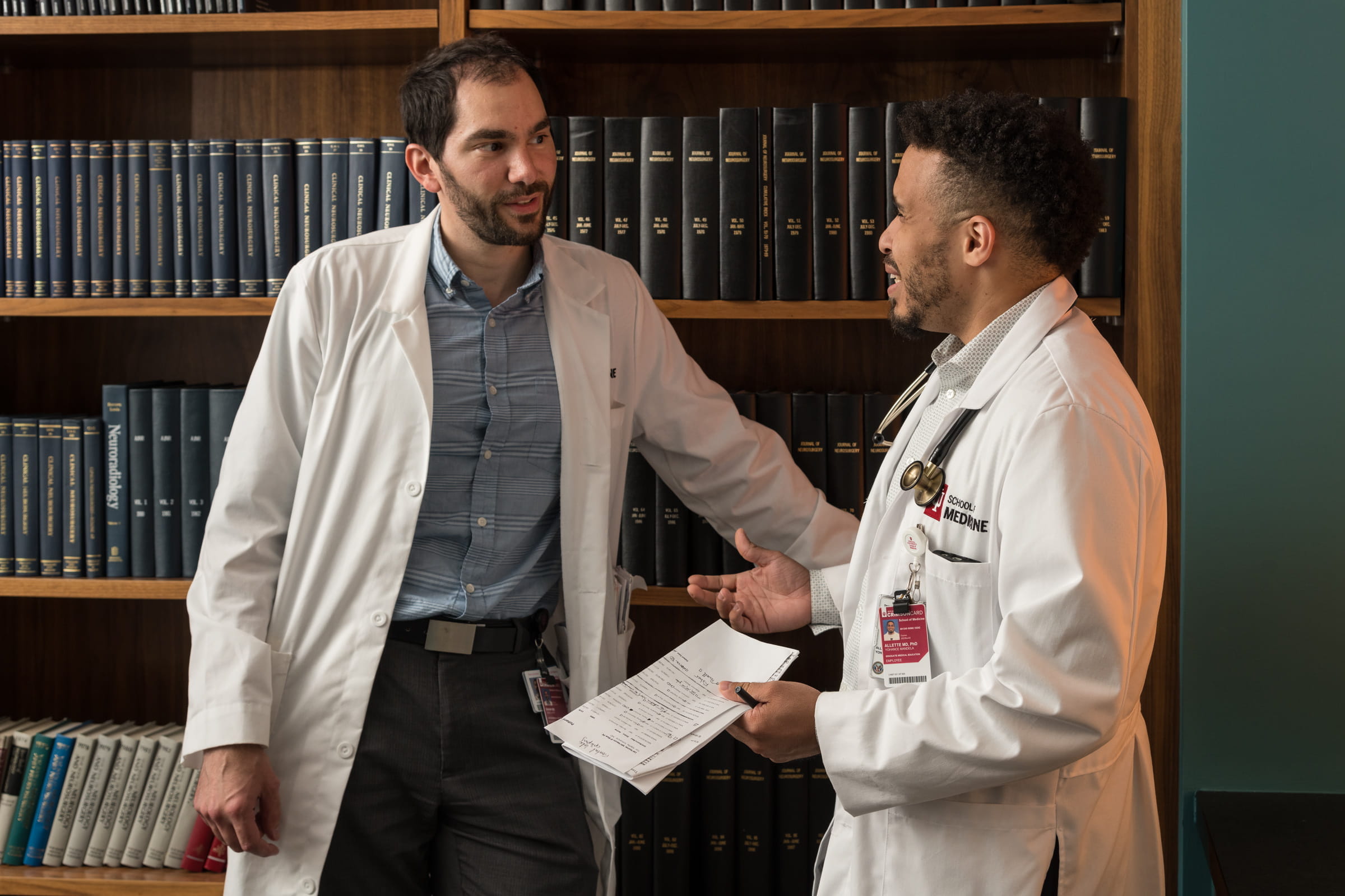 neurology residents chat in a library