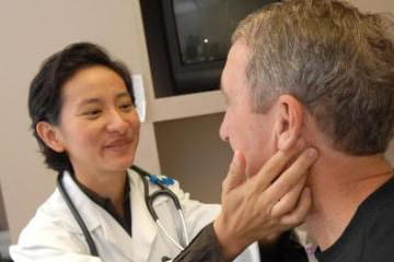 a female doctor holds the neck of a patient during an exam