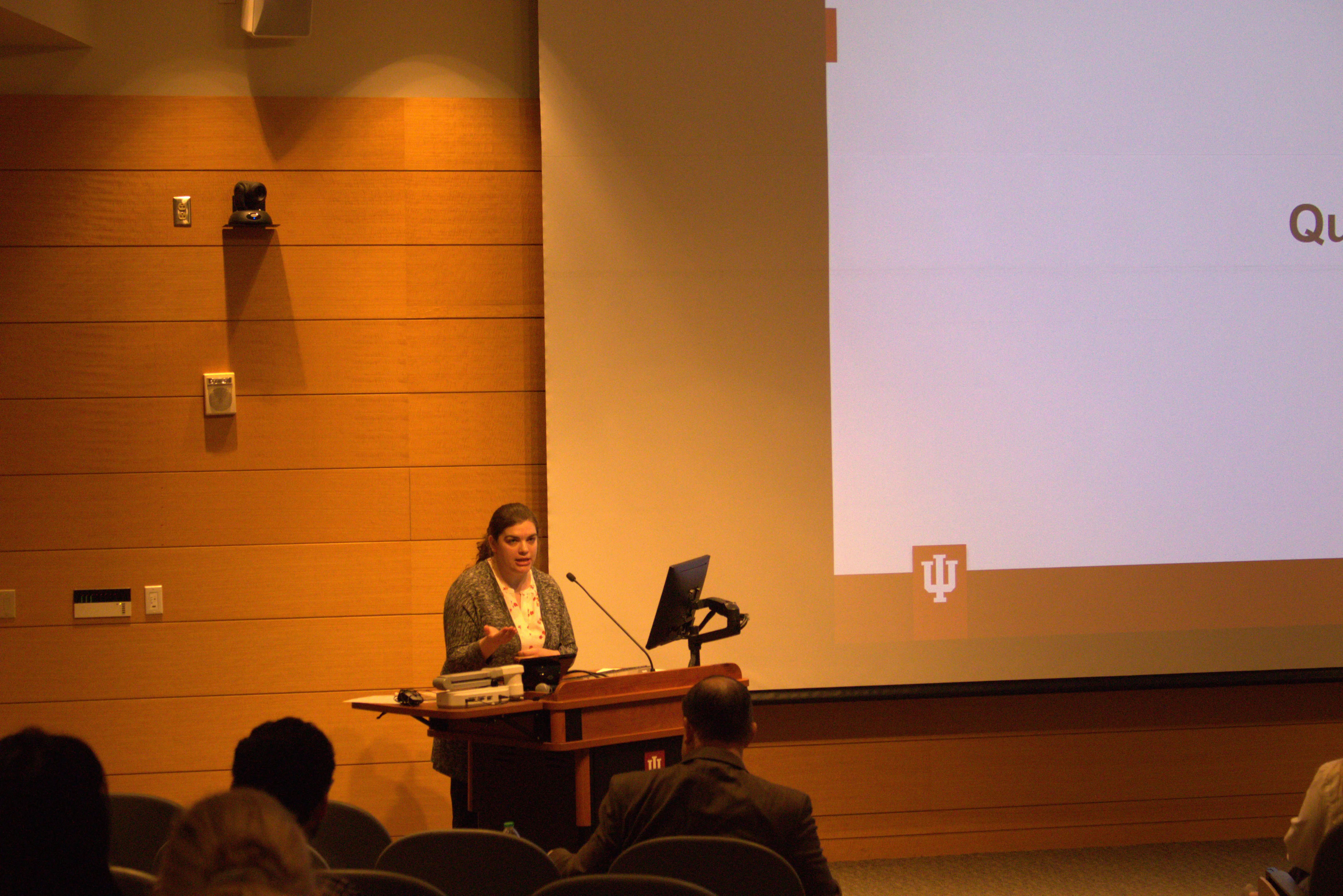 Dr. Emma Ryan stands at the lectern in front of the audience