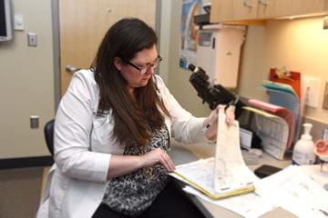 Elizabeth Martin, MD, looks over files in an exam room in the Eugene and Marilyn Glick Eye Institute at the IU School of Medicine Department of Ophthalmology.
