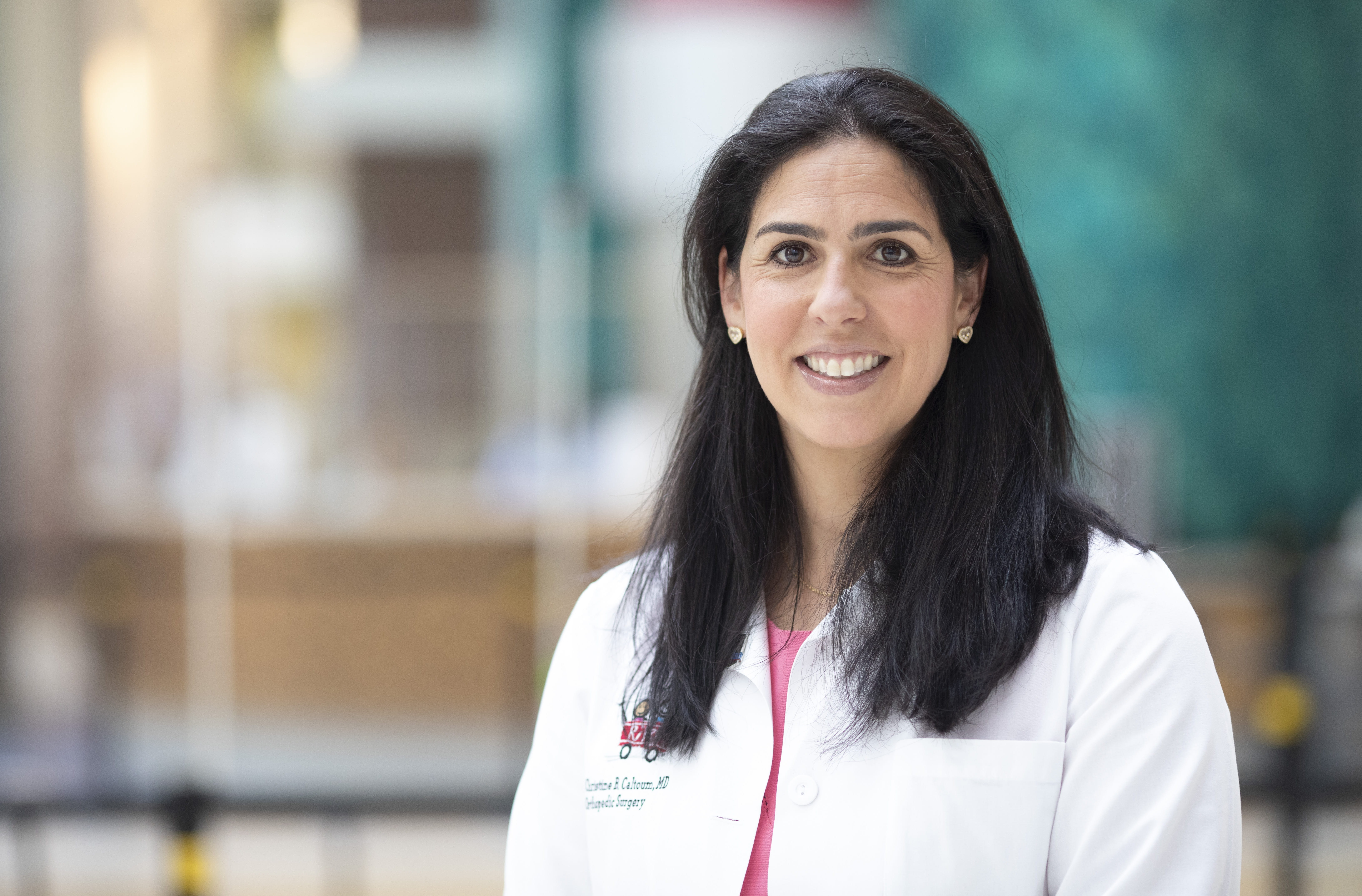 Christine Caltoum, wearing her white Riley Children's Hospital coat, smiles for her headshot.