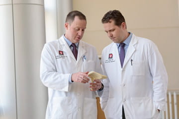 two doctors examine a model of a bone