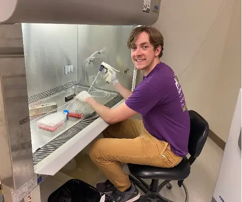 Nicholas Thelen works with research equipment in the Gingery Lab, where he is studying as part of the IMPRS program. 