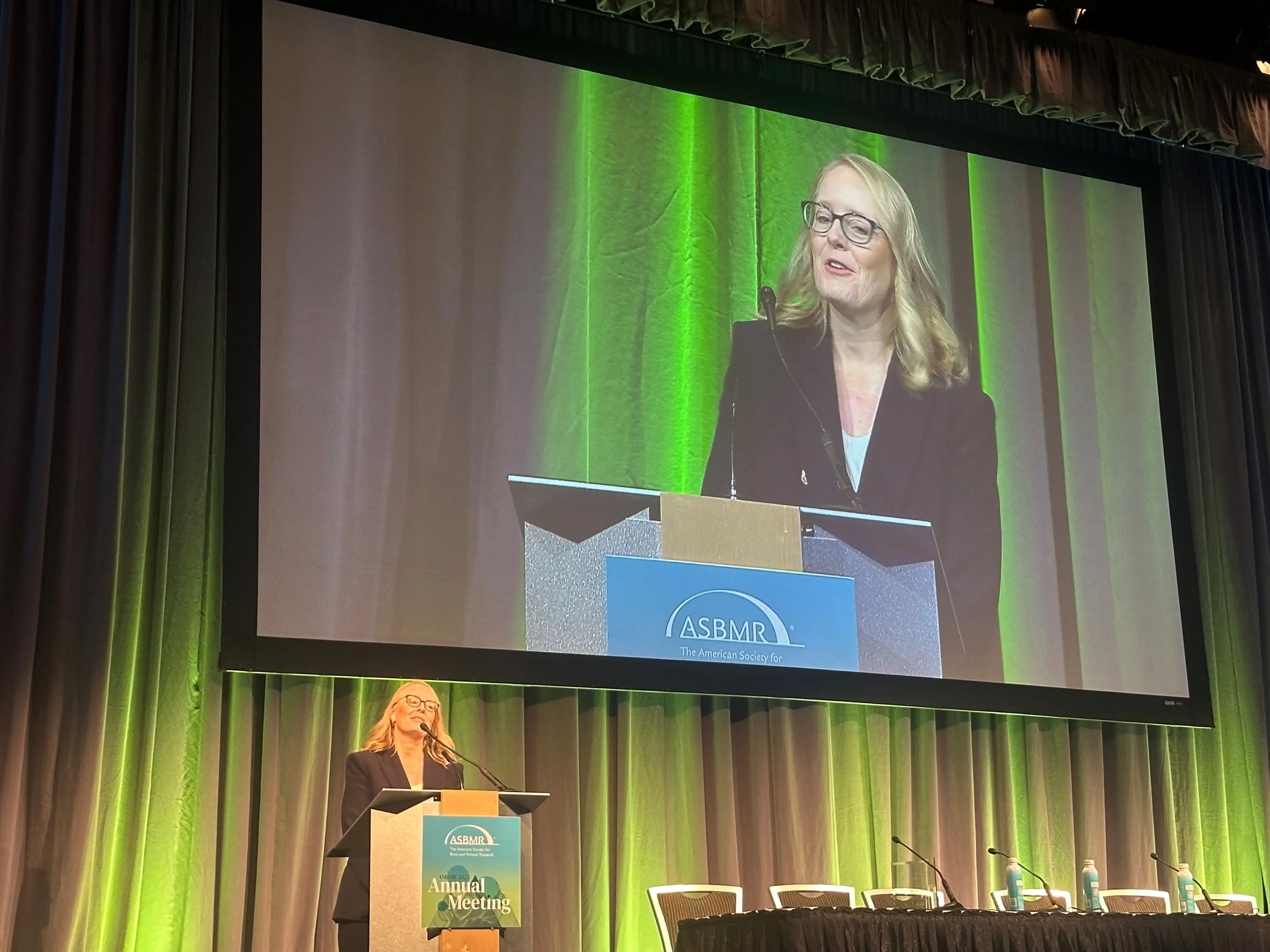 Melissa Kacena speaks at a podium as she accepts the 2023 Stephen M. Krane Award