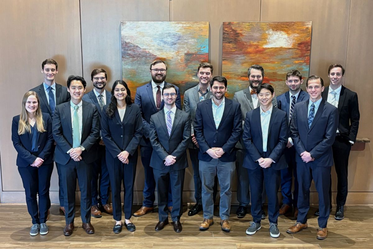 Group of men and women in professional attire posing for group picture