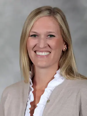 Person in professional attire smiling at camera