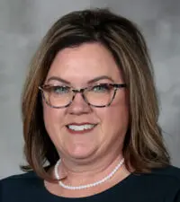 Person in professional attire smiling at camera