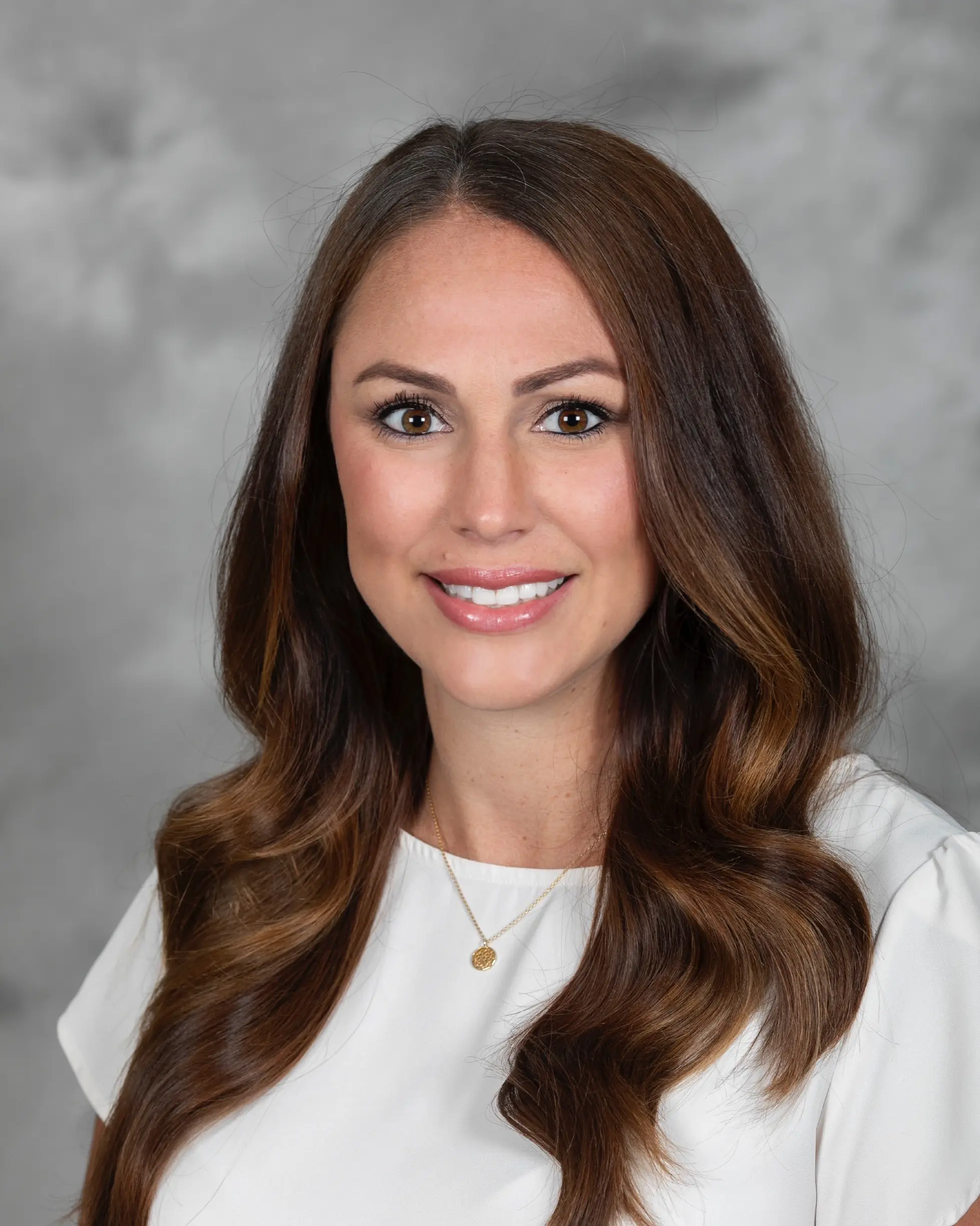 Person in professional attire smiling at camera