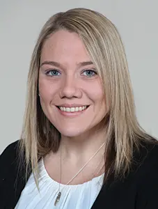 Person in professional attire smiling at camera