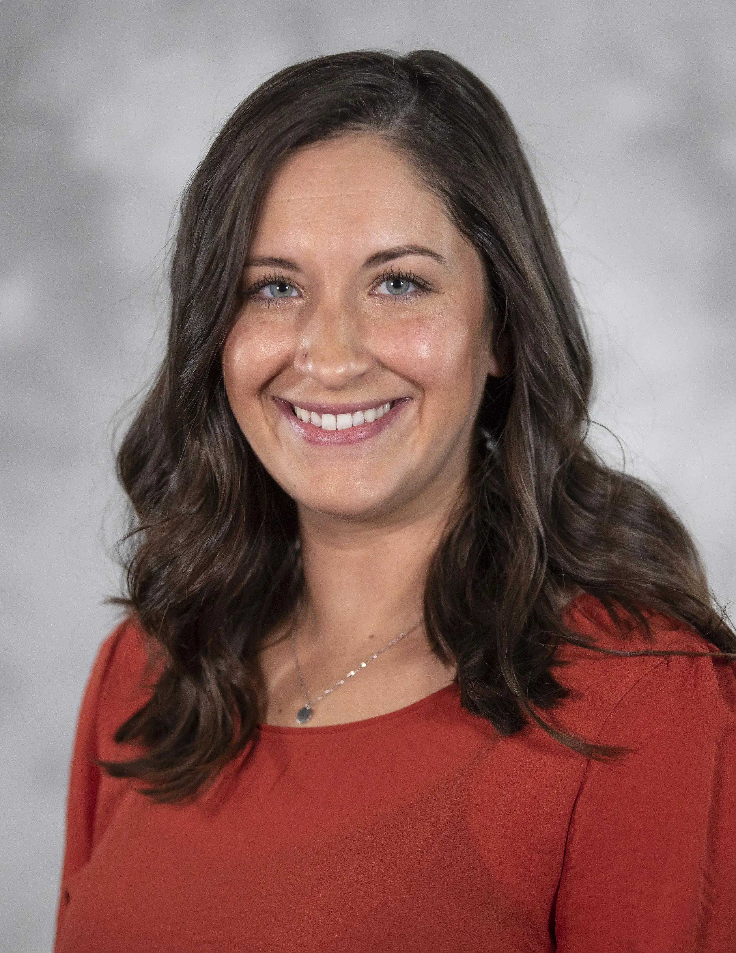 Person in professional attire smiling at camera