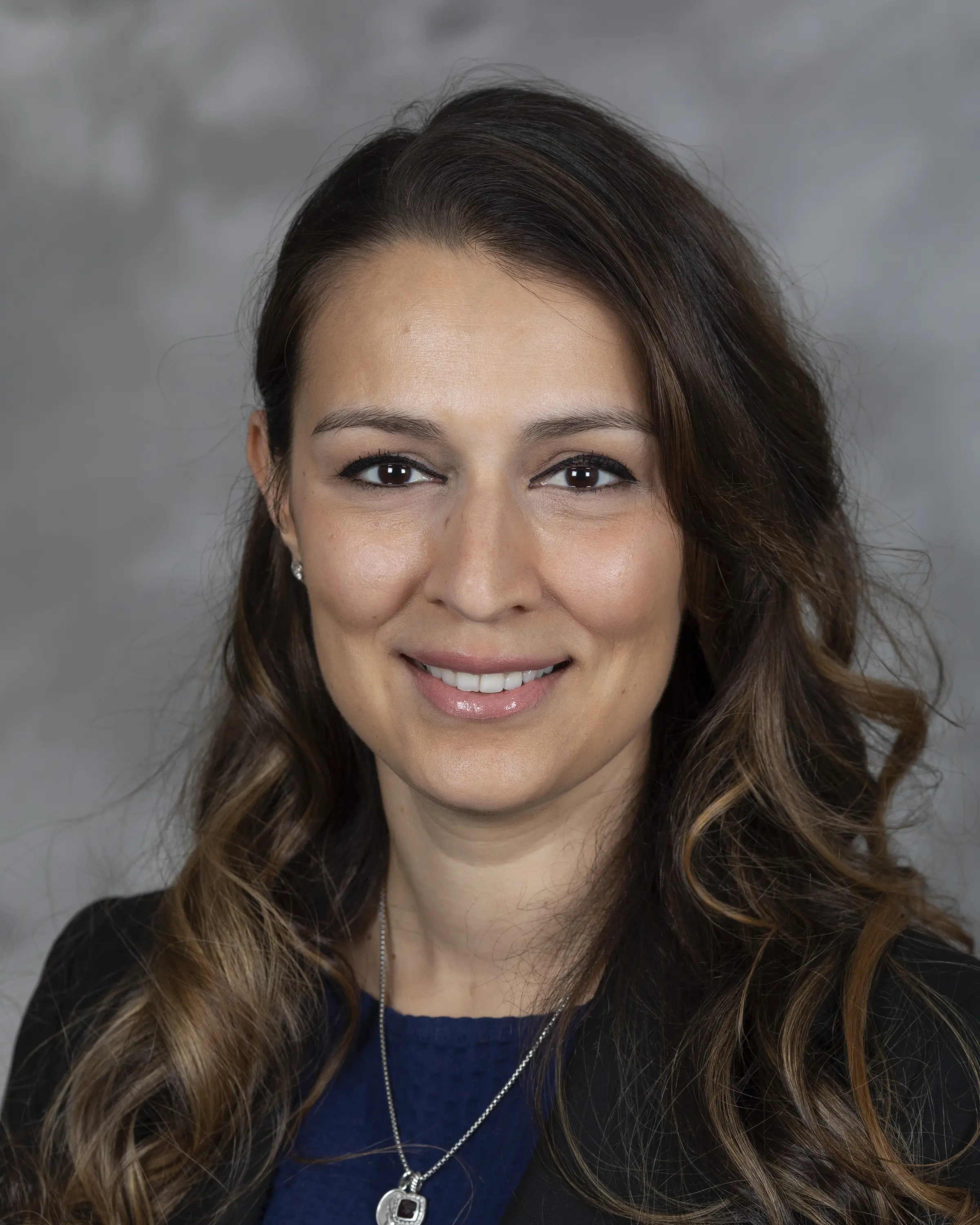 Person in professional attire smiling at camera