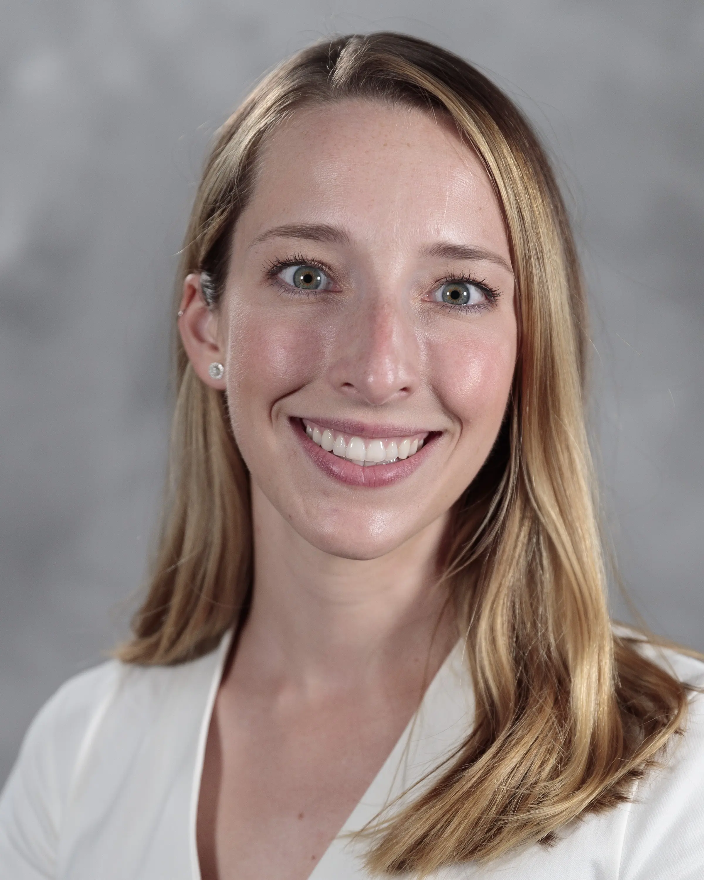 Person in professional attire smiling at camera