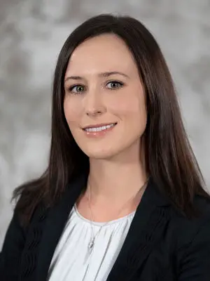 Person in professional attire smiling at camera