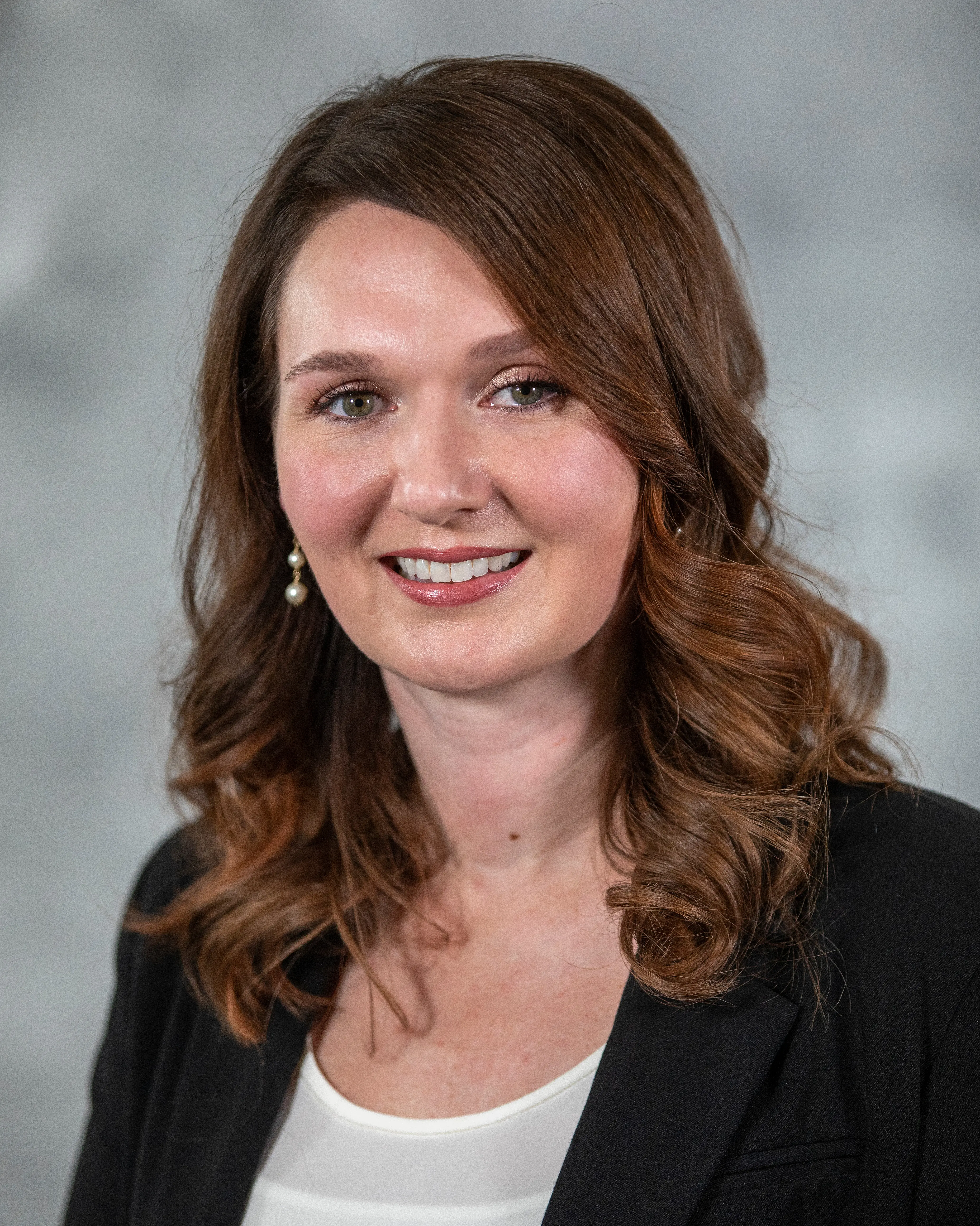 Person in professional attire smiling at camera