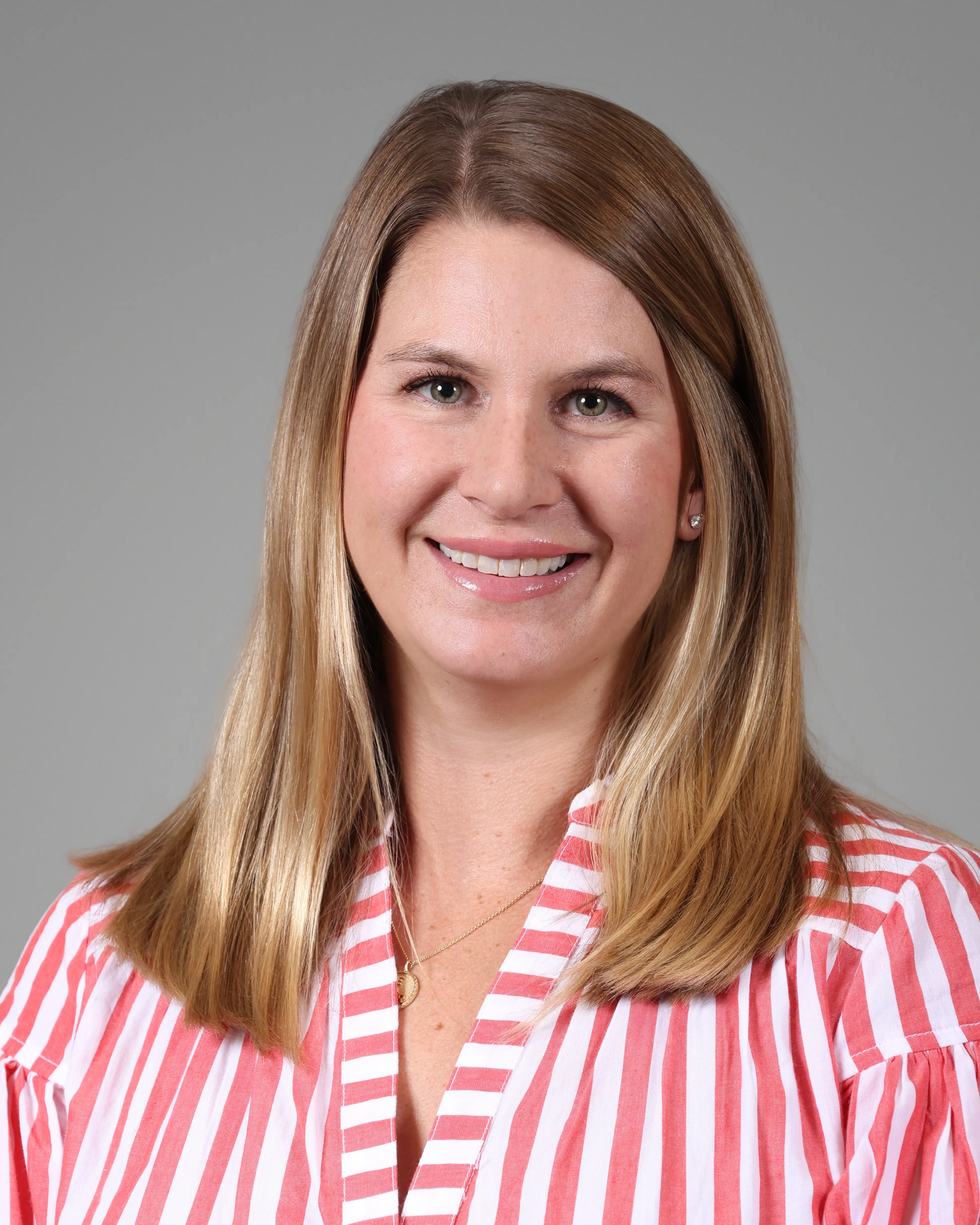 Person in professional attire smiling at camera