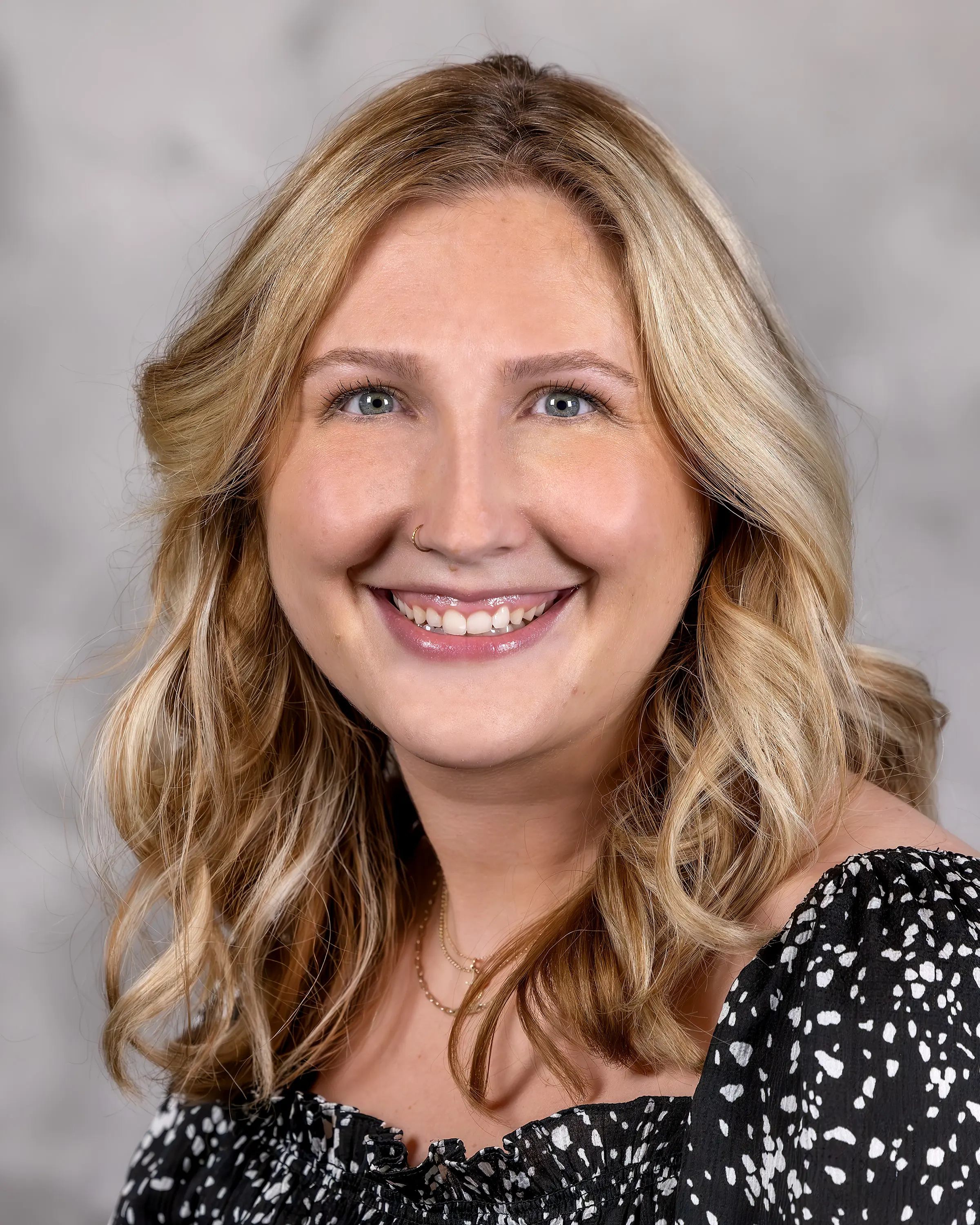 Person in professional attire smiling at camera