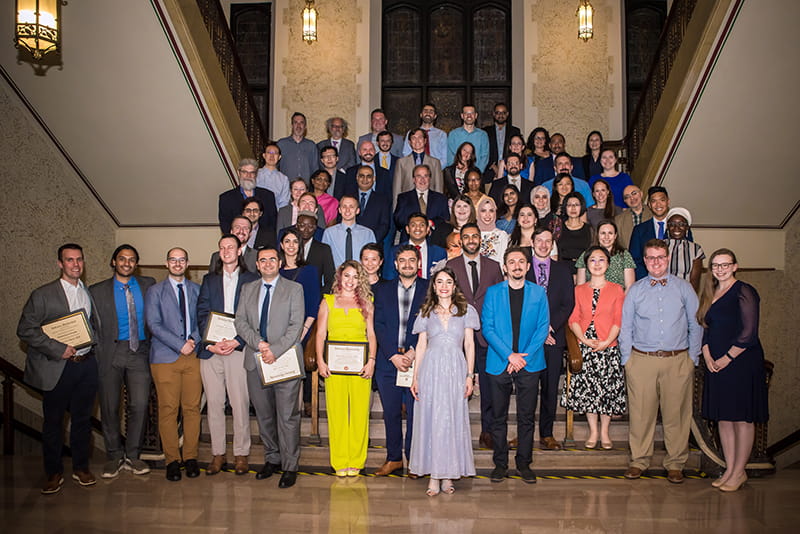 large group of residents in formal attire holding awards