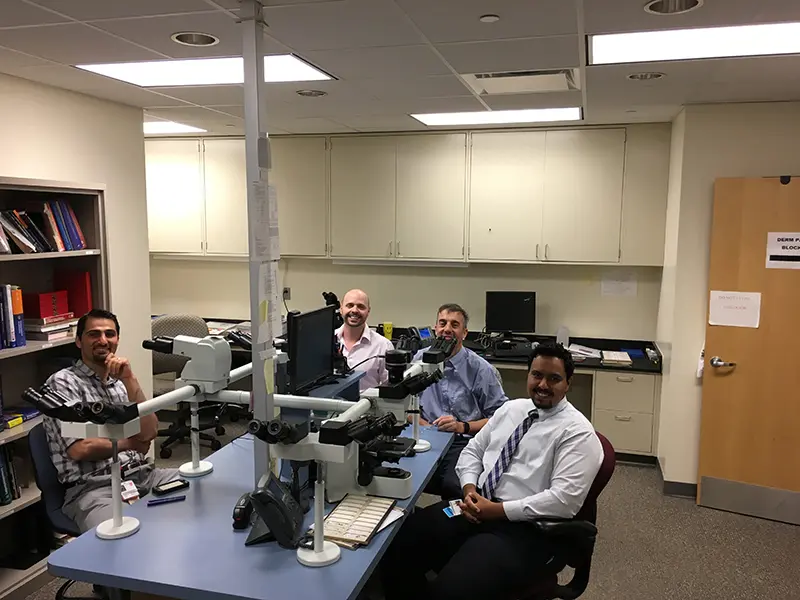 Four pathologists smile at the camera