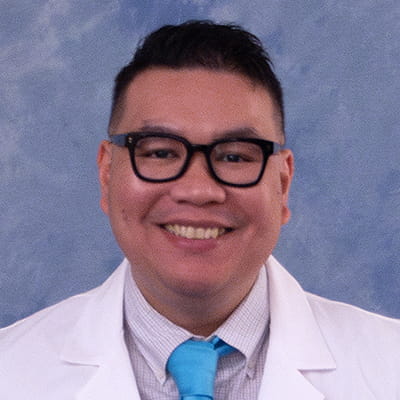 Joel in a white lab coat