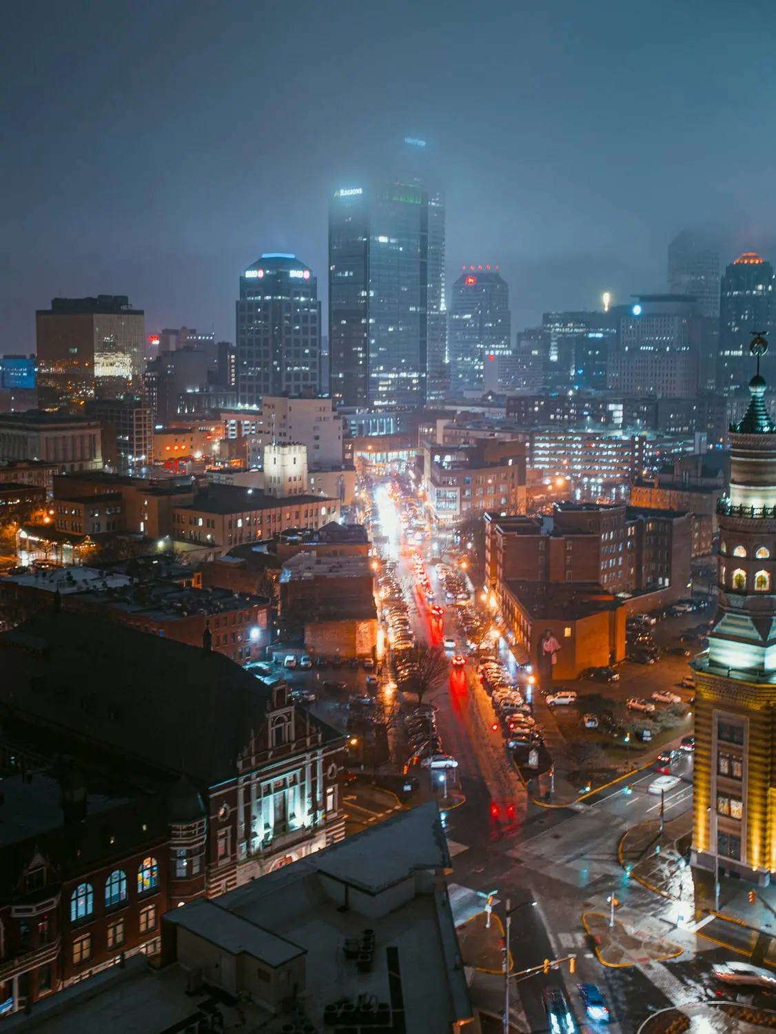 Aerial view of downtown Indianapolis with buildings lit up on a foggy night