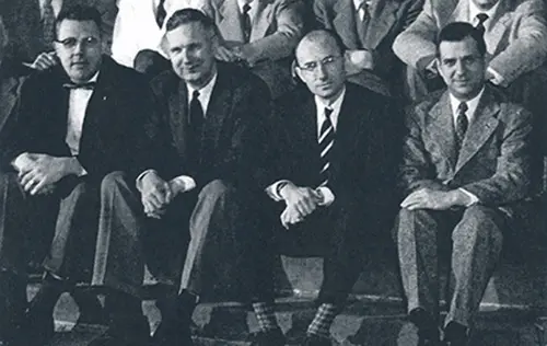 Drs. Beamer, Smith, Schulz and Vellios sit together as part of a larger group photo