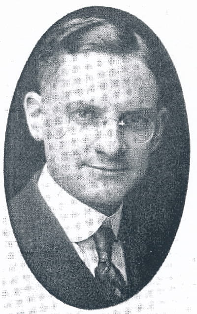 Black and white oval portrait of Dr. Forry, wearing a suit and tie and glasses