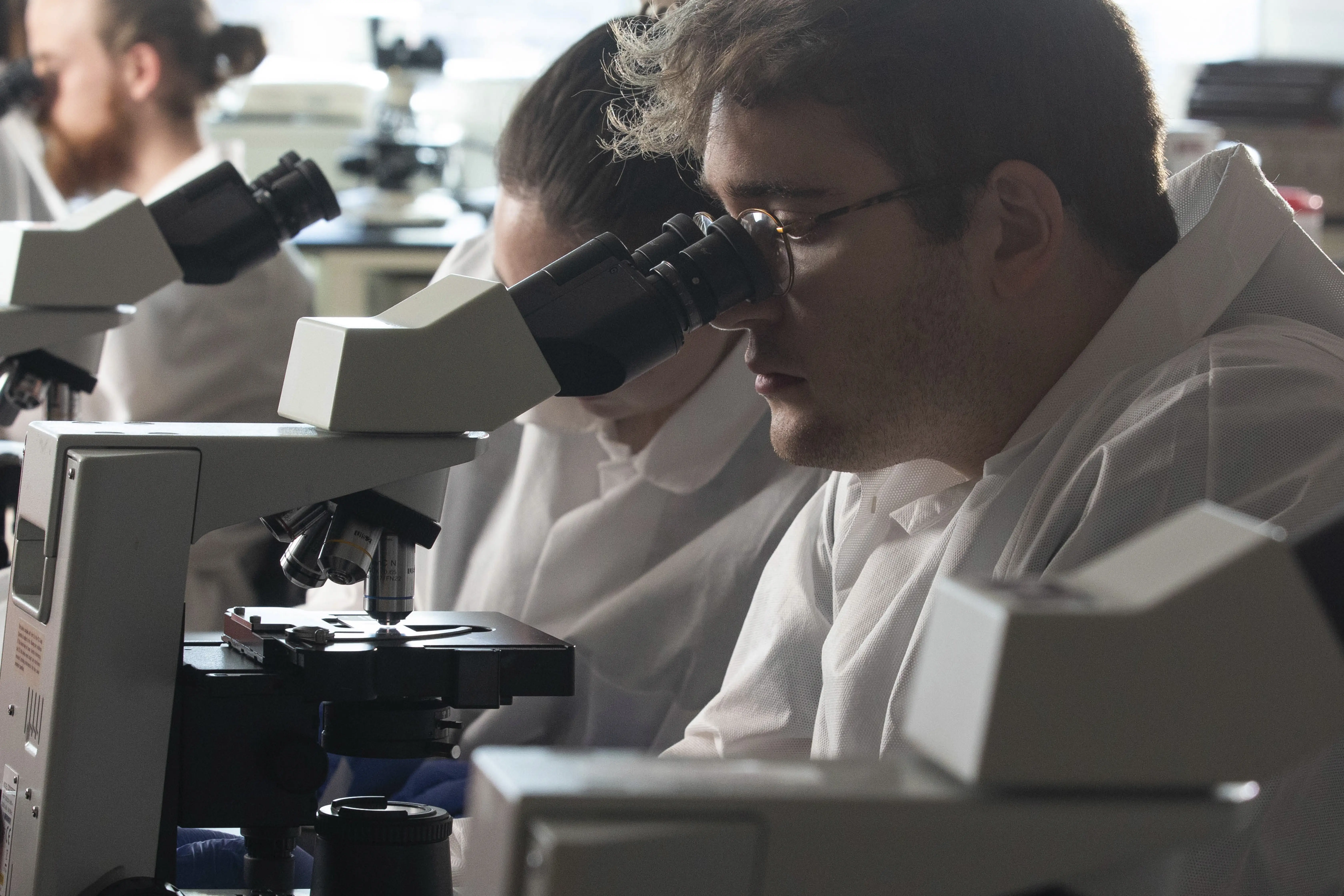 Hystotechnology student looking at a microscope