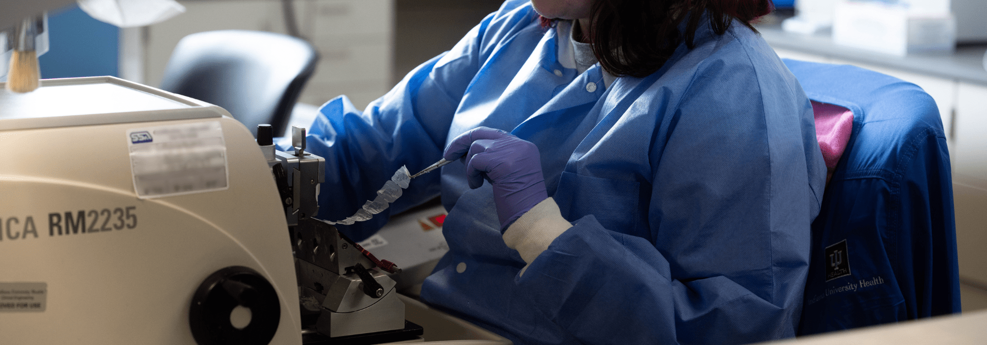 Clinical care pathologist using lab technology looking at a slide