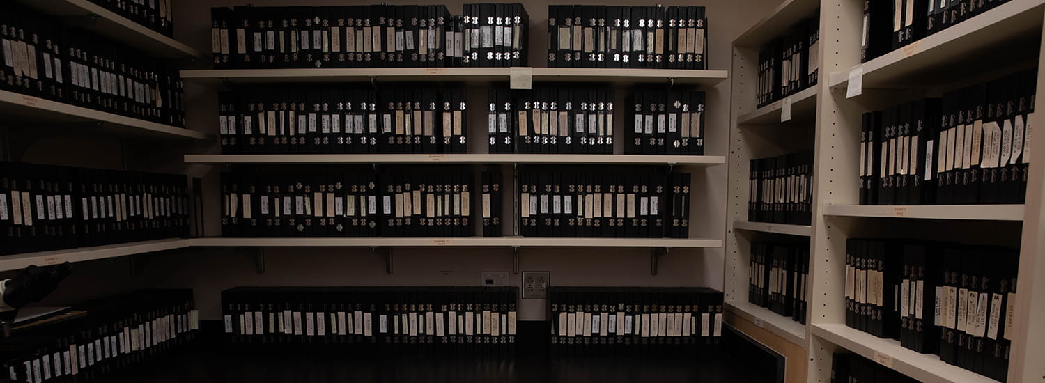 Rows of neatly organized binders line the shelves of an archival storage room, each labeled and carefully cataloged. The scene captures the commitment to preserving valuable records, ensuring easy access to historical data for future research and reference.