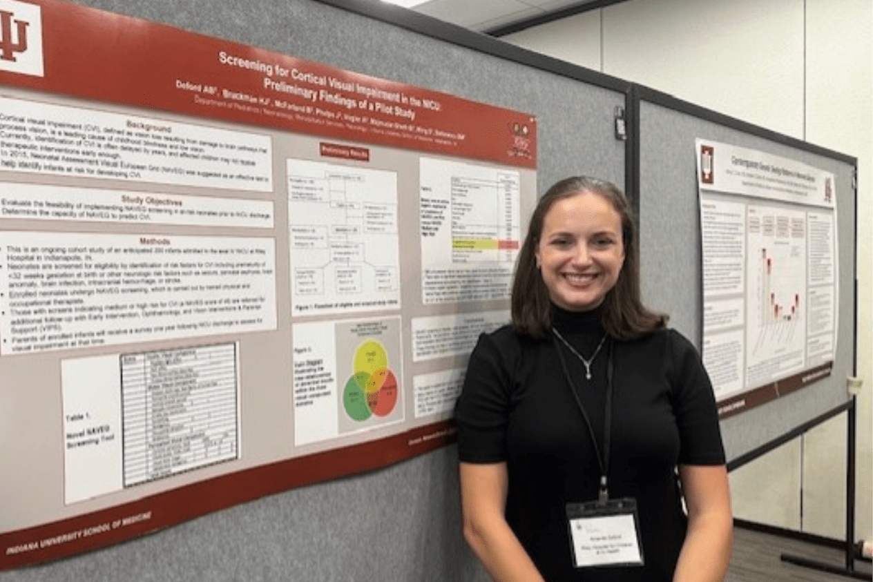 Woman presenting a poster at a conference