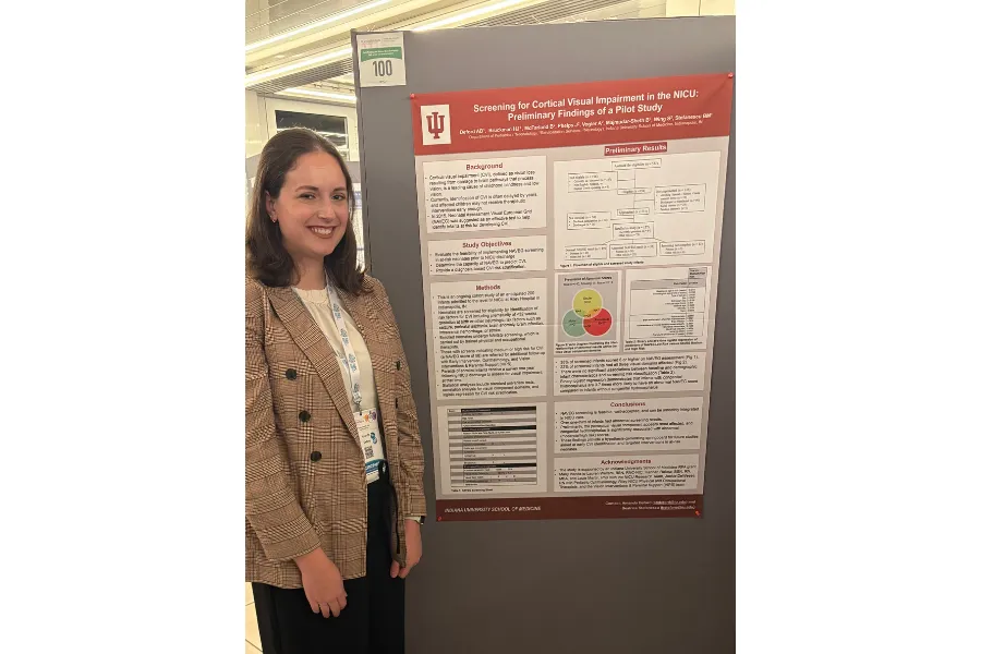 Photo of a woman standing in front of a poster