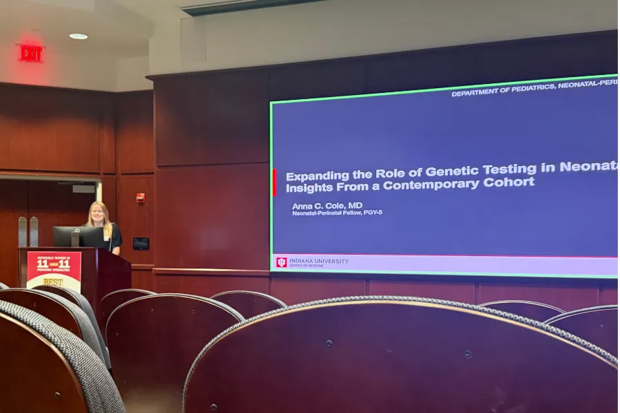 Photo of a woman giving a presentation in an auditorium 