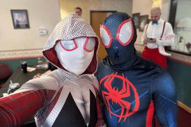 Emily Sims, MD (left) dressed up as Spider-Gwen and Mike DeSante (right) dressed up as Spiderman at Media Night, where dances are recorded to play on the television feed for voting by Riley kids