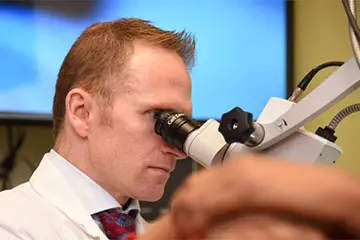 Doctor looking through an ENT device