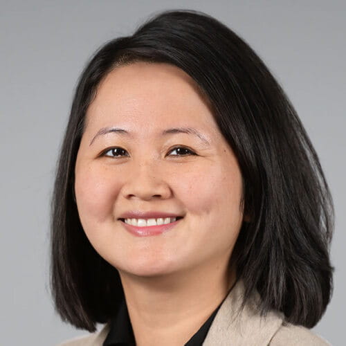 Headshot of a woman in a tan coat