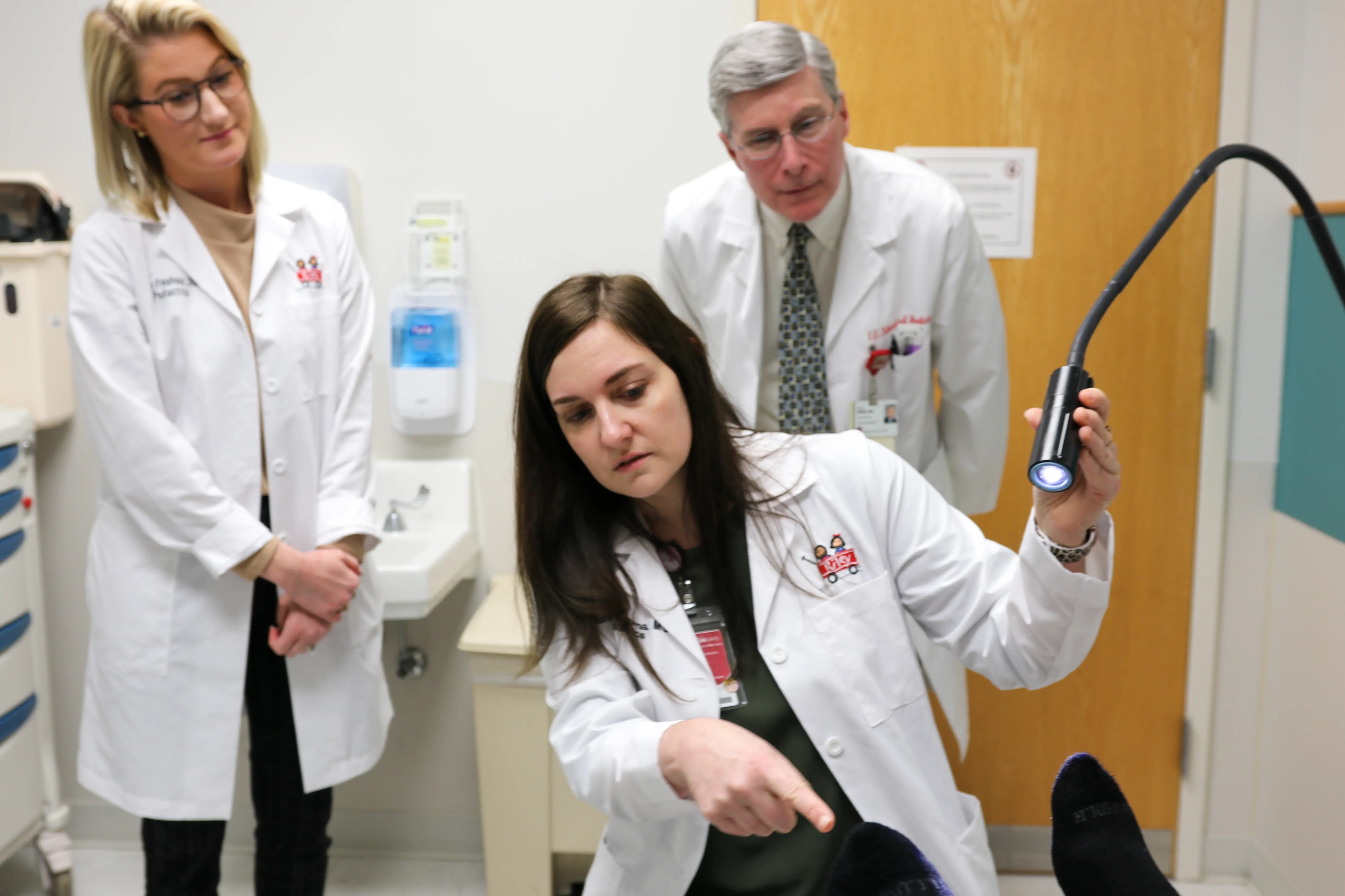 Three faculty observing a patient during a visit
